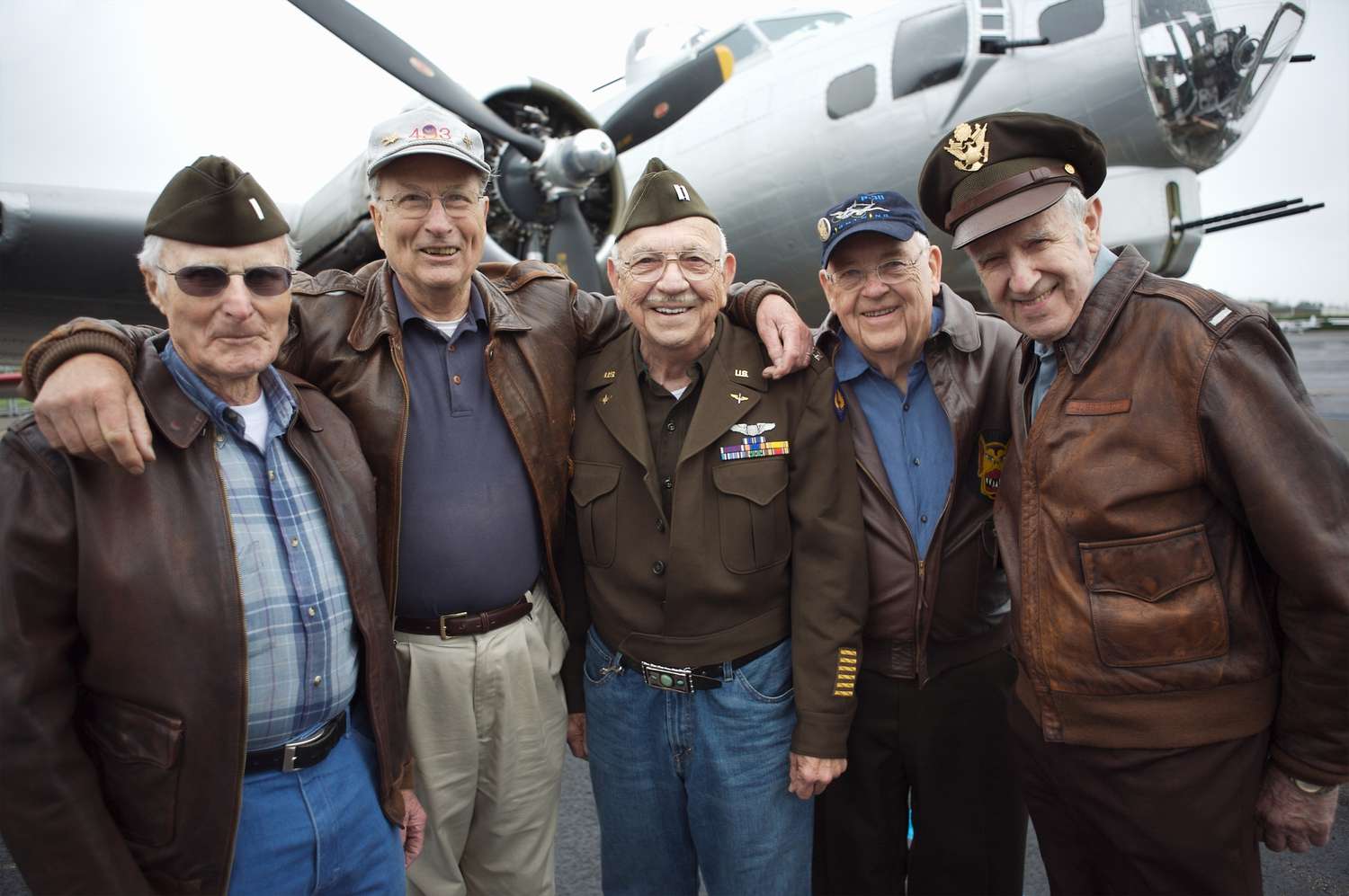 Veterans gathered in front of a vintage aircraft